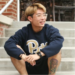 Student in Pitt sweatshirt on stairs