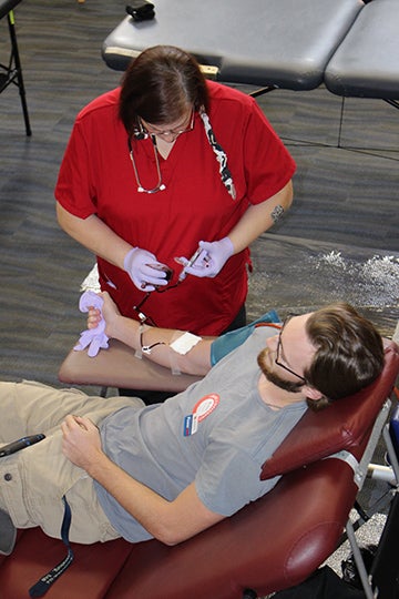 Red Cross nurse attending patient at blood drive