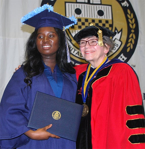 Student posing with President Sharon Smith