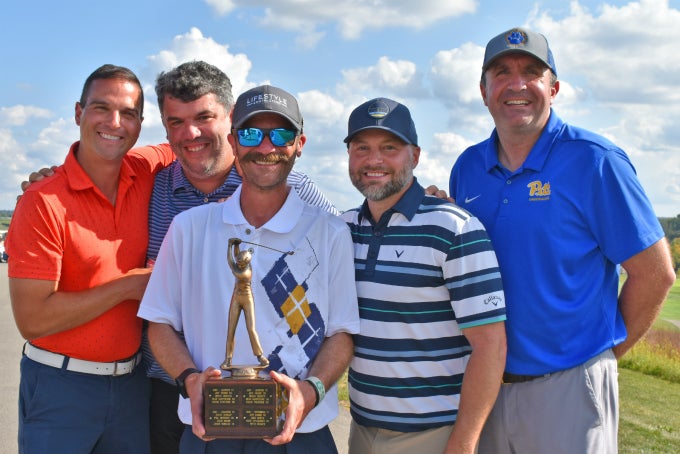 Five individuals posing with Golf Outing trophy