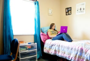 Student studying in Westmoreland Hall bedroom