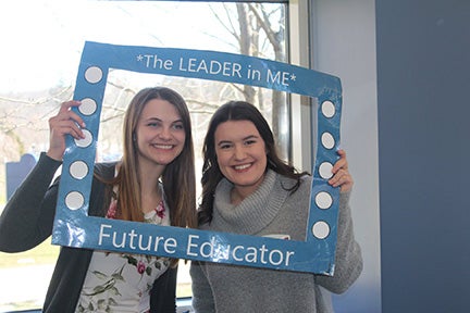 Two students posing with sign reading "The Leader in Me - Future Educator"