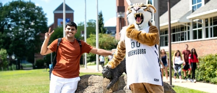 Student posing with Bobcat mascot