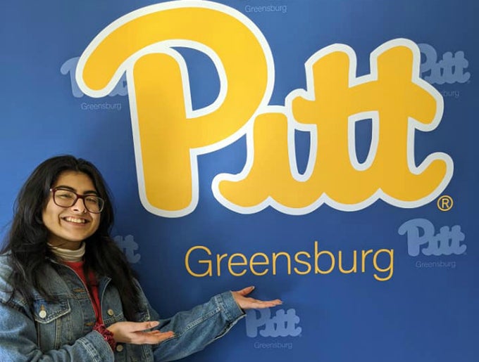 Student in front of Pitt-Greensburg sign