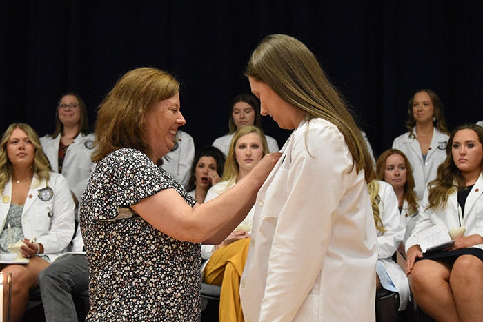 A family member pins a nursing student during the 2024 Pinning Ceremony