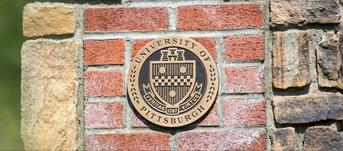University seal on brick wall