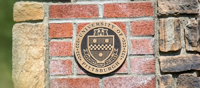 University seal on brick wall