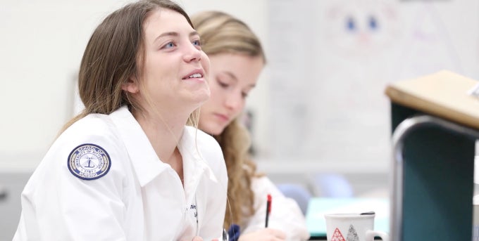 Nursing student smiling, seated in class