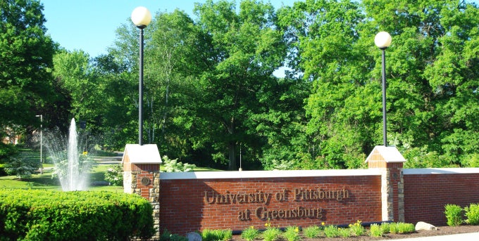 View of entrance wall of campus, with campus fountain in the background
