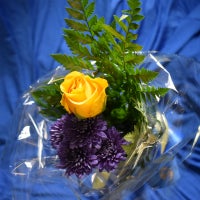 One (1) single yellow rose with greens, wrapped in cellophane, and tied with a ribbon. $7.50 each