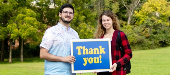 Two students holding sign reading "Thank you!"