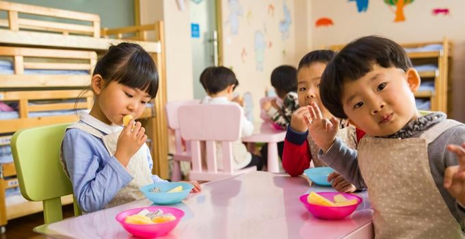 young students eating in a classroom