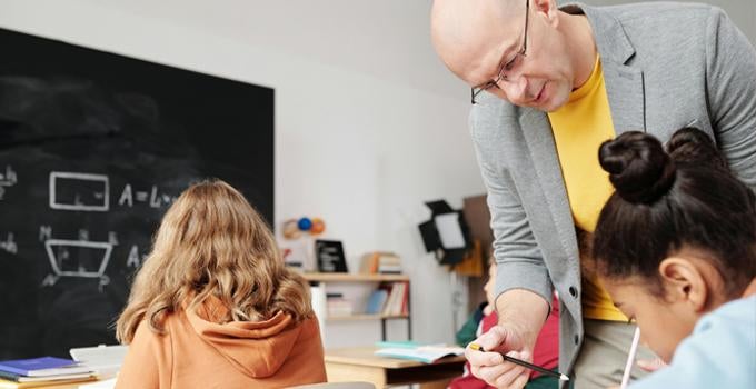 teacher helping a student in a classroom
