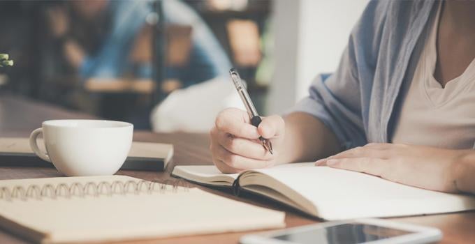 person writing in a notebook