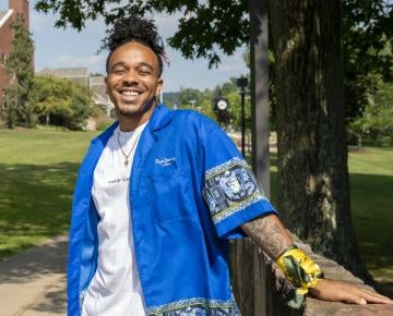Student smiling, leaning on wall